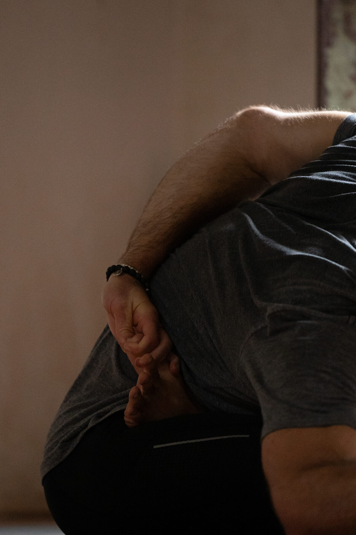 Nick in a seated wrapped posture, holding his foot